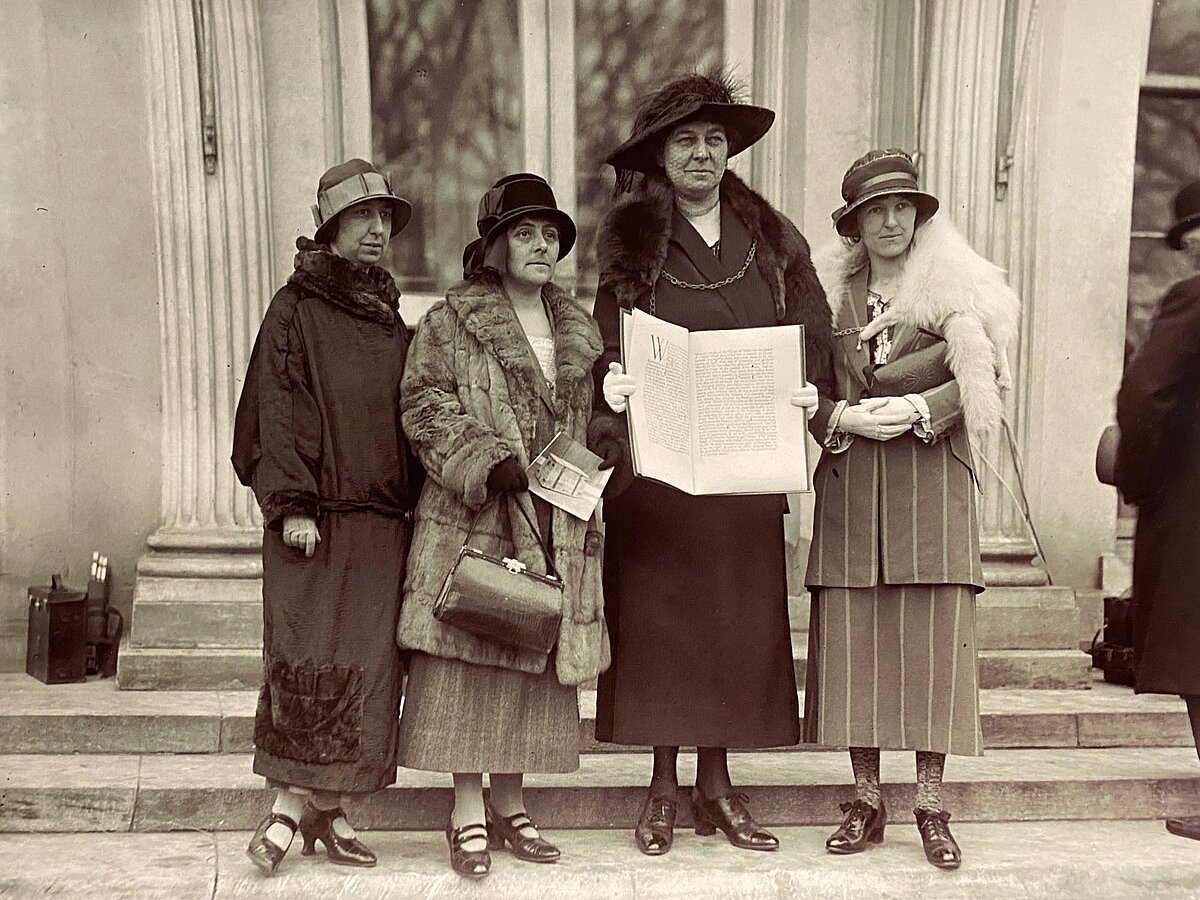 Annie Hughes Griffiths holding a copy of the Appeal outside the White House in Washington following their meeting with President Calvin Coolidge in 1924, alongside Gladys Thomas, Mary Ellis and Elined Prys (L-R).