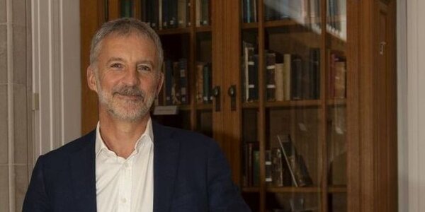 Professor Richard Wyn Jones pictured at the National Library of Wales with a shelf of books in the background