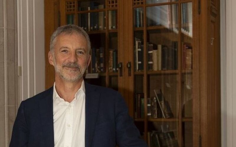 Professor Richard Wyn Jones pictured at the National Library of Wales with a shelf of books in the background