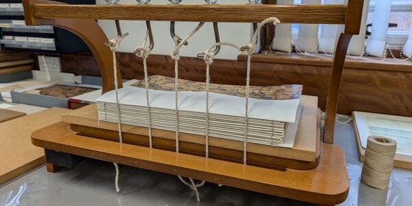 Manuscript pages gathered and pressed in a wooden binder