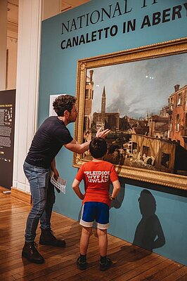 Person and child looking at Canaletto painting