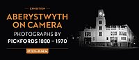 Exhibition banner for Aberystwyth on Camera Photographs by Pickfords 1880-1970 (image of the old King's Hall at night)