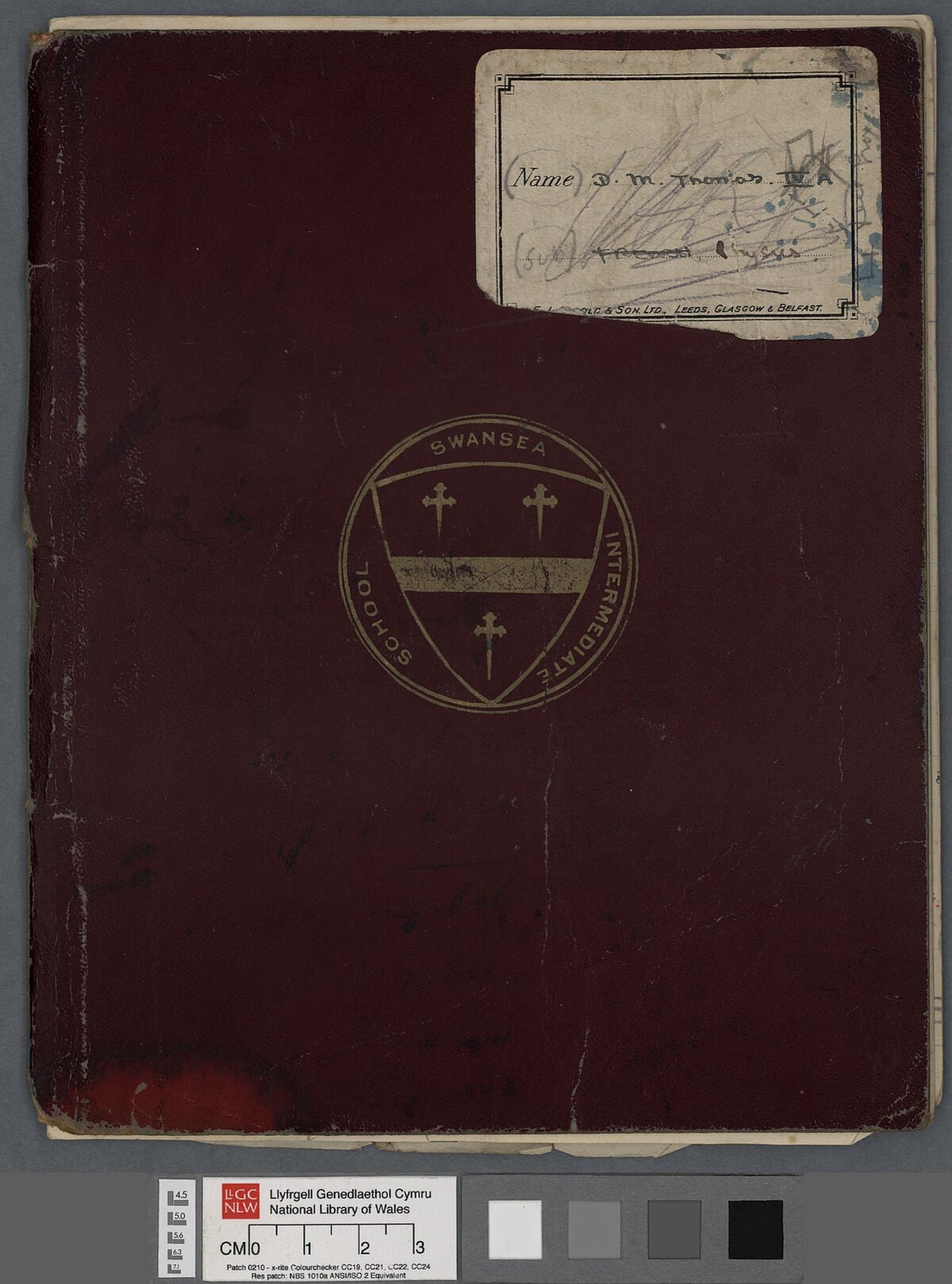 A burgundy Swansea Intermediate School exercise book belonging to Dylan Thomas, and labelled 'D.M. Thomas IV A Physics'.