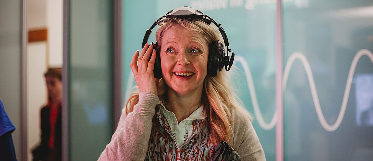 A woman wearing headphones in the Wales Broadcast Archive