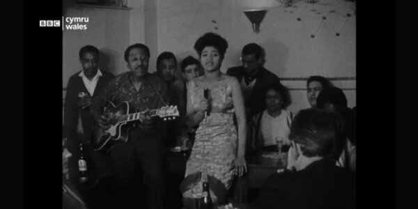 A screengrab from a black and white film of musicians performing at the Ghana Club, including Clara Graham and Vic Parker.