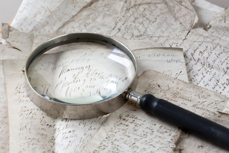 A magnifying glass lying on a document from the Library's collections
