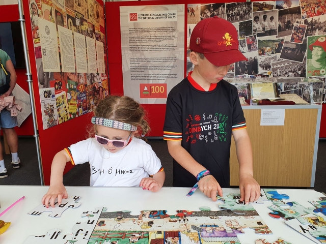 Two children completing a jigsaw at the National Library tent in the Eisteddfod h