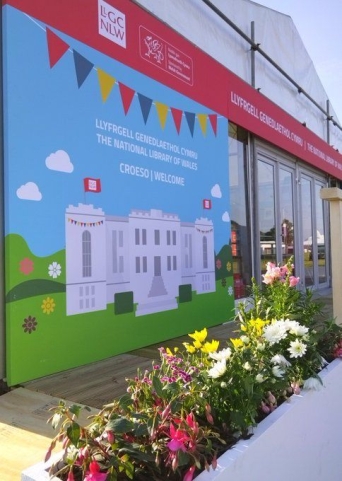 The promotional graphic of the National Library of Wales building on the side of the Library tent at the Eisteddfod h