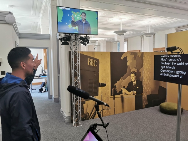 Person reading an autocue to tell the weather using a greenscreen h