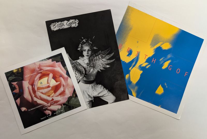 A collection of three pamphlets from the Brith Gof Archive showing (l-r) an image of a rose; a performer in costume; and the text 'Brith Gof' in red on a blue and yellow background