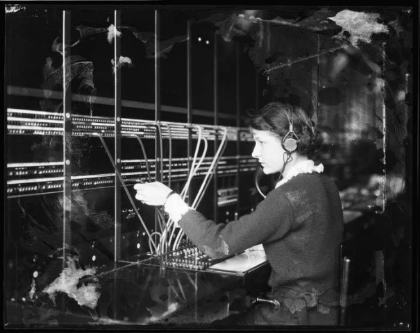 A switchboard operator (taken from https://commons.wikimedia.org/wiki/File:Telephone_switchboard_operators,_ca_1922_(MOHAI_5108).jpg) 
