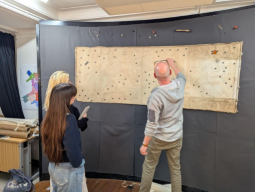 a map stuck to a curved wall using magnets