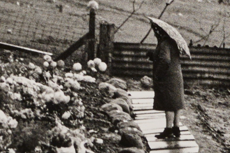 Person at the Aberfan Memorial holding an umbrella